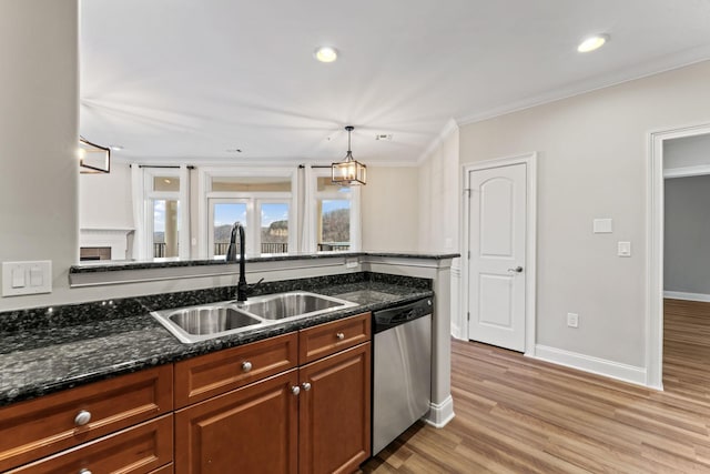 kitchen featuring sink, stainless steel dishwasher, dark stone countertops, ornamental molding, and decorative light fixtures