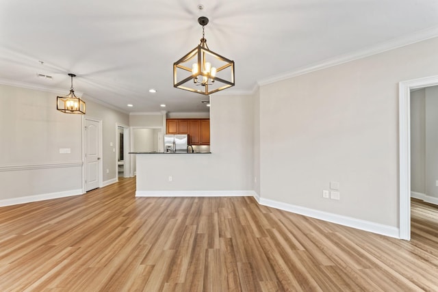 unfurnished living room with a notable chandelier, light wood-type flooring, and ornamental molding