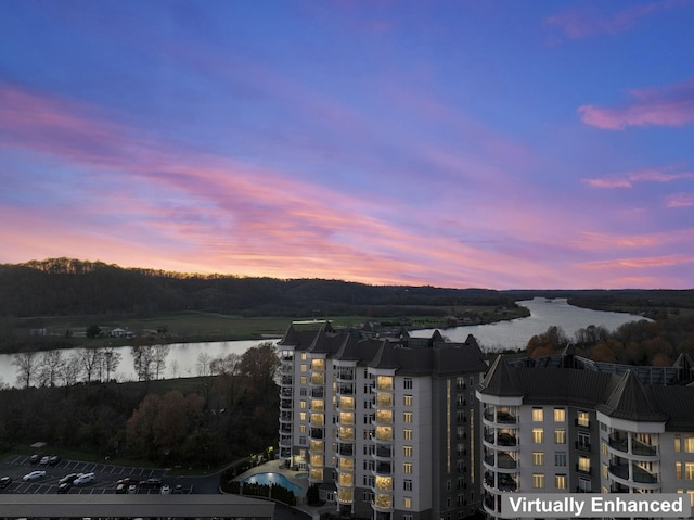 aerial view at dusk featuring a water view