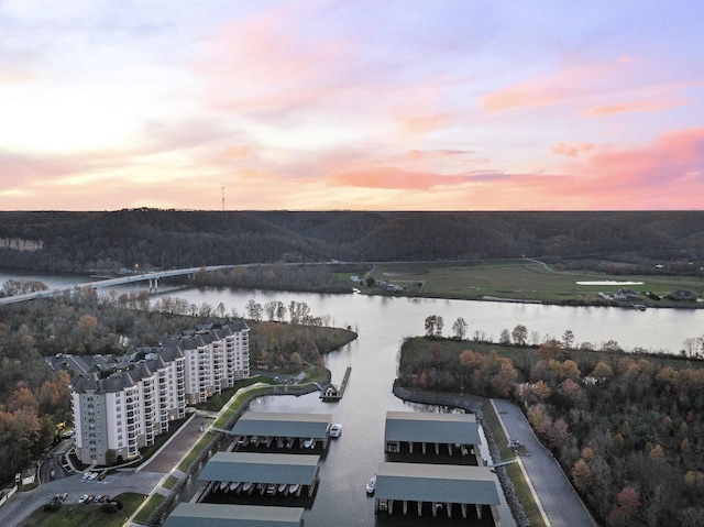 aerial view at dusk featuring a water view