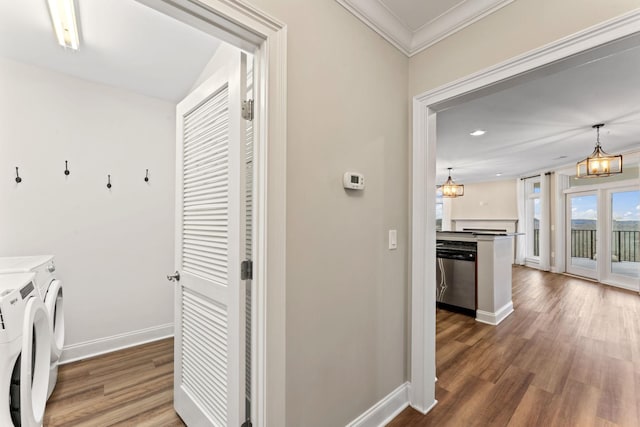 washroom featuring a chandelier, washing machine and dryer, dark hardwood / wood-style floors, and ornamental molding