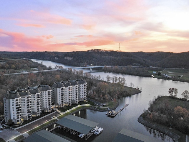 aerial view at dusk featuring a water view