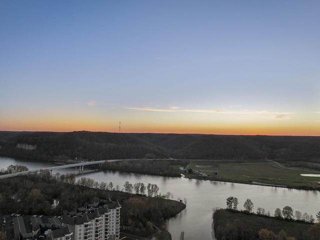 aerial view at dusk featuring a water view