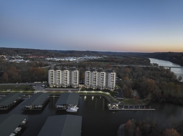 aerial view at dusk featuring a water view