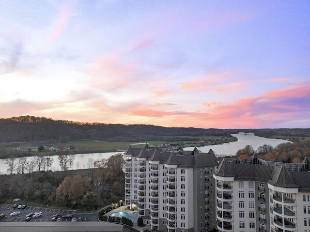 aerial view at dusk featuring a water view