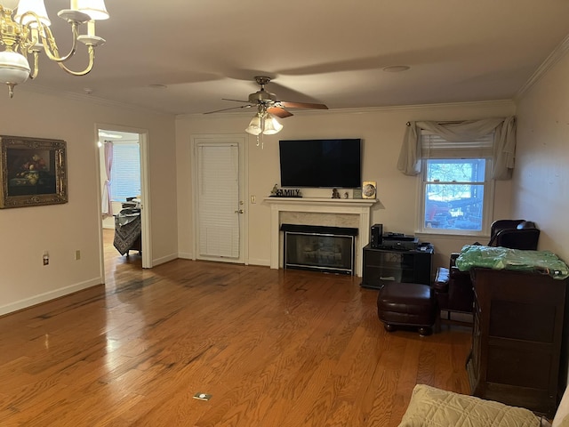 living room with hardwood / wood-style floors, ceiling fan with notable chandelier, and ornamental molding