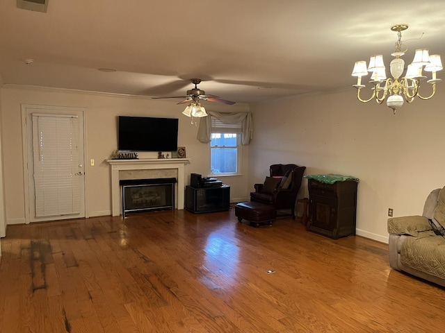 unfurnished living room with hardwood / wood-style floors, ceiling fan with notable chandelier, and crown molding