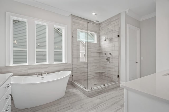 bathroom featuring shower with separate bathtub, vanity, tile walls, and ornamental molding