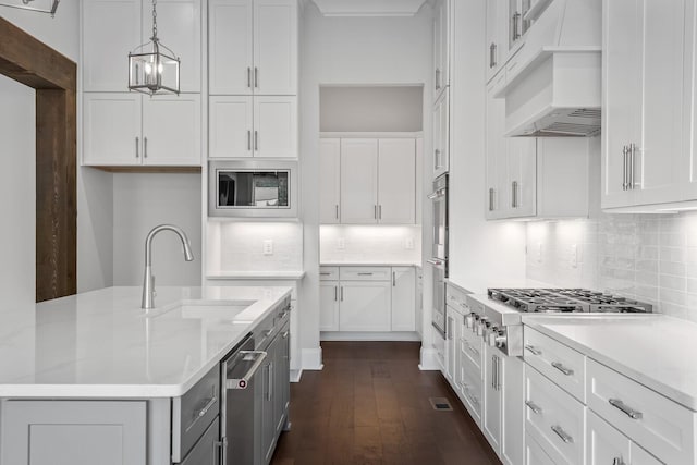 kitchen featuring premium range hood, stainless steel appliances, sink, pendant lighting, and white cabinetry