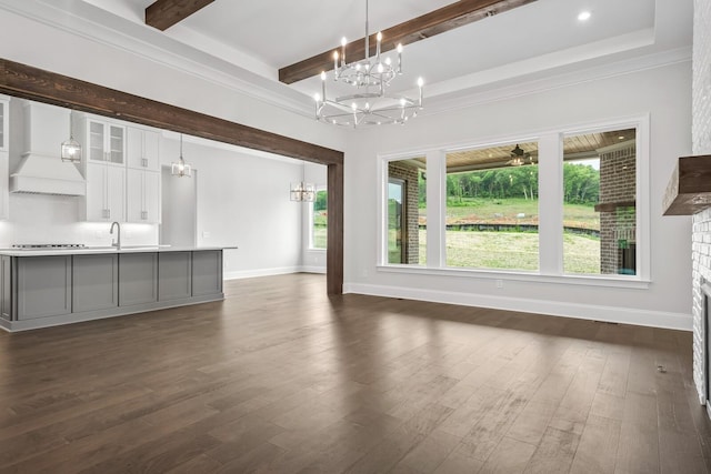 unfurnished living room with dark hardwood / wood-style floors, beam ceiling, and sink