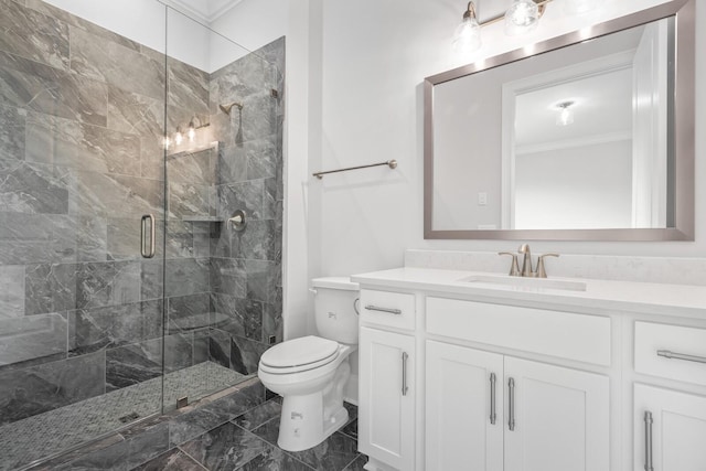 bathroom featuring vanity, toilet, a shower with door, and ornamental molding