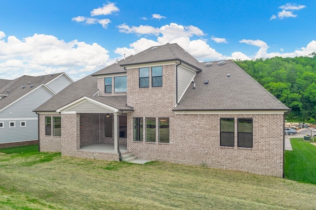 rear view of property with a yard and a patio