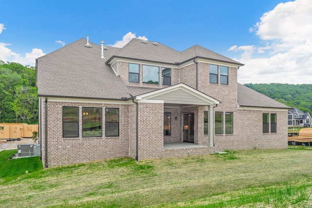 back of house with a patio area and a yard