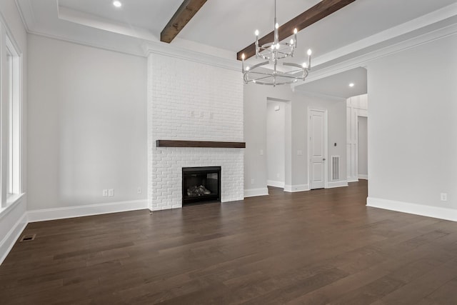 unfurnished living room with beam ceiling, an inviting chandelier, dark hardwood / wood-style flooring, crown molding, and a fireplace