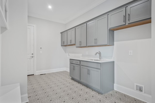 laundry area with hookup for a washing machine, sink, cabinets, and ornamental molding