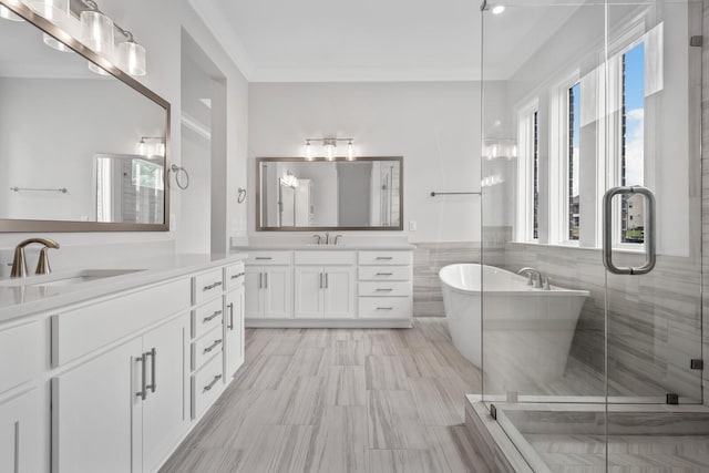 bathroom featuring vanity, separate shower and tub, tile walls, and ornamental molding