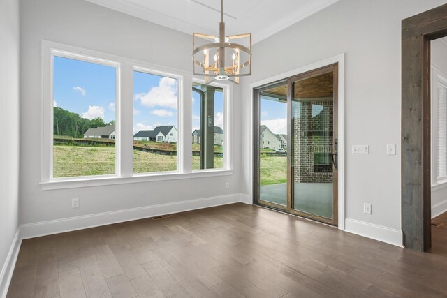 unfurnished dining area featuring a chandelier and dark hardwood / wood-style floors