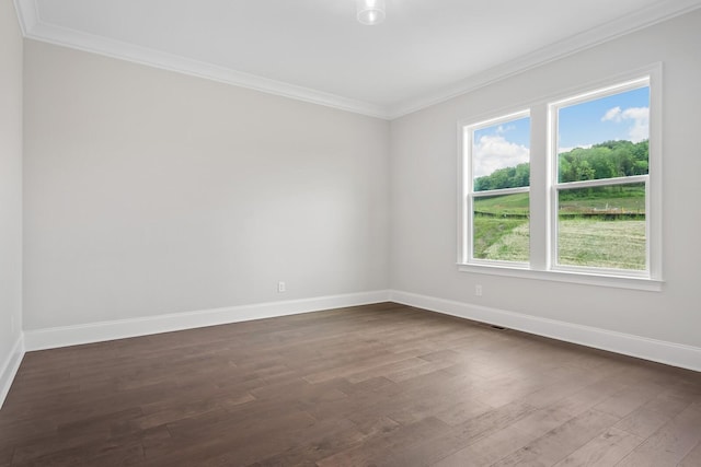 spare room featuring dark hardwood / wood-style flooring and crown molding