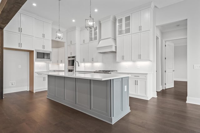 kitchen featuring white cabinets, sink, an island with sink, and appliances with stainless steel finishes