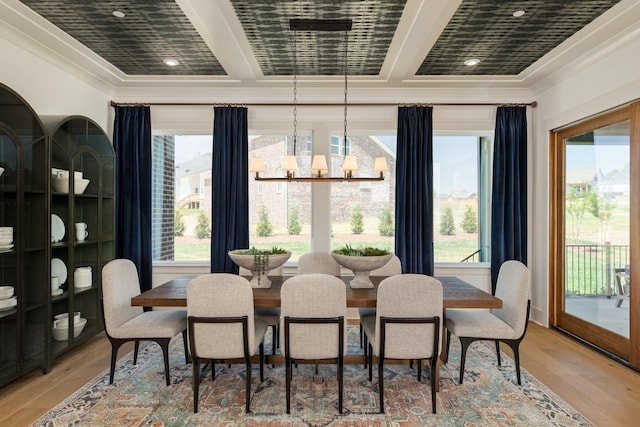 dining space with crown molding, light hardwood / wood-style floors, and an inviting chandelier