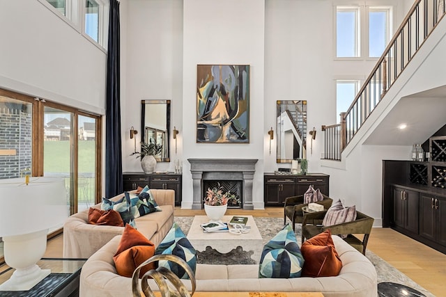 living room with light hardwood / wood-style floors and a high ceiling