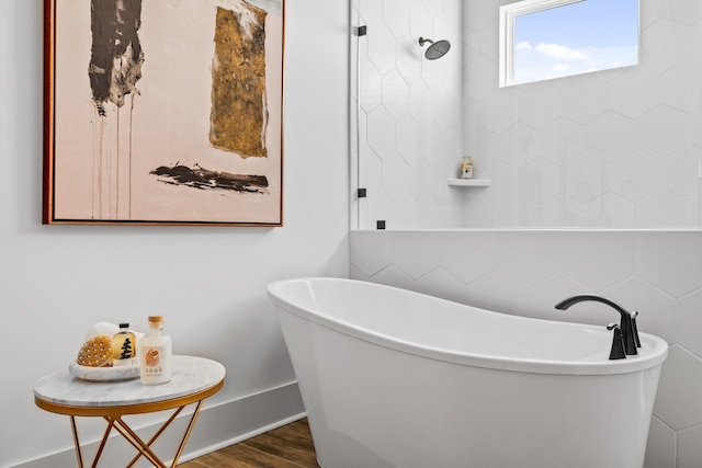 bathroom featuring hardwood / wood-style floors and a tub to relax in