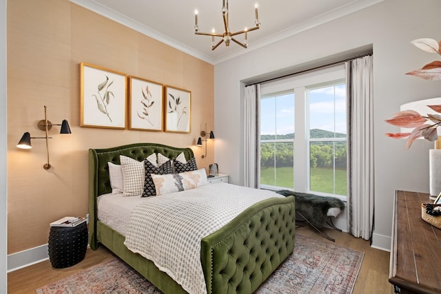 bedroom featuring hardwood / wood-style floors, a notable chandelier, and ornamental molding