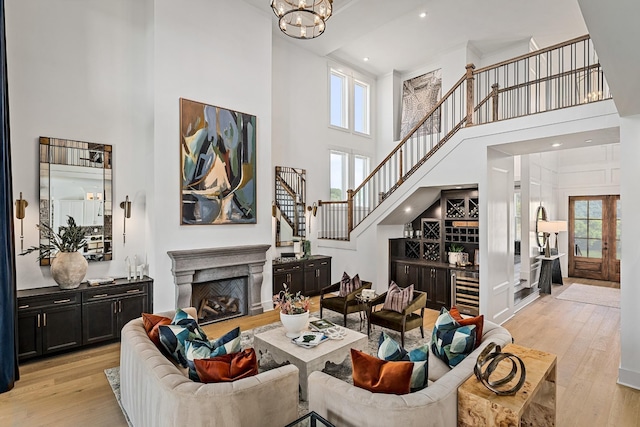 living room featuring light hardwood / wood-style floors, a healthy amount of sunlight, and a towering ceiling