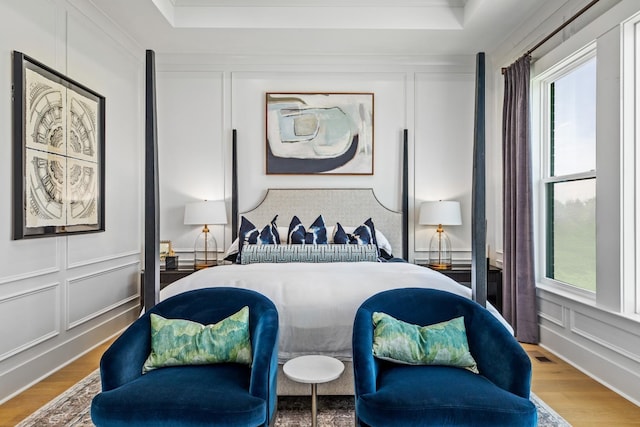 bedroom featuring a raised ceiling and wood-type flooring