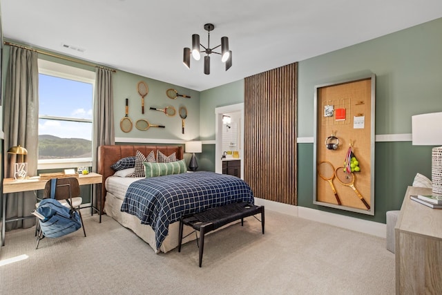 carpeted bedroom featuring connected bathroom and a notable chandelier