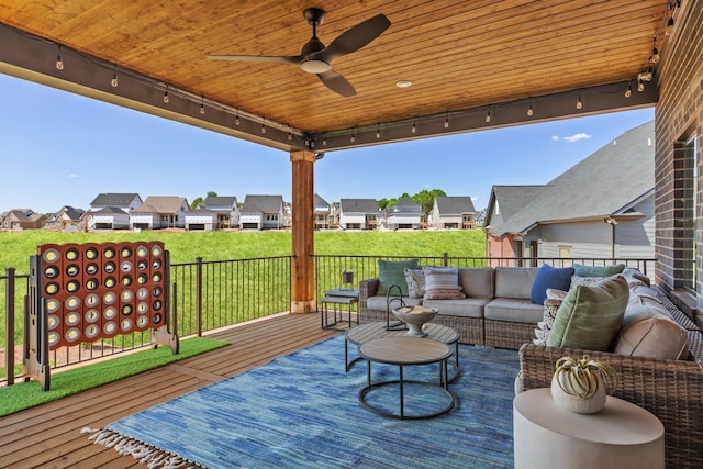 wooden deck with ceiling fan, an outdoor hangout area, and a yard