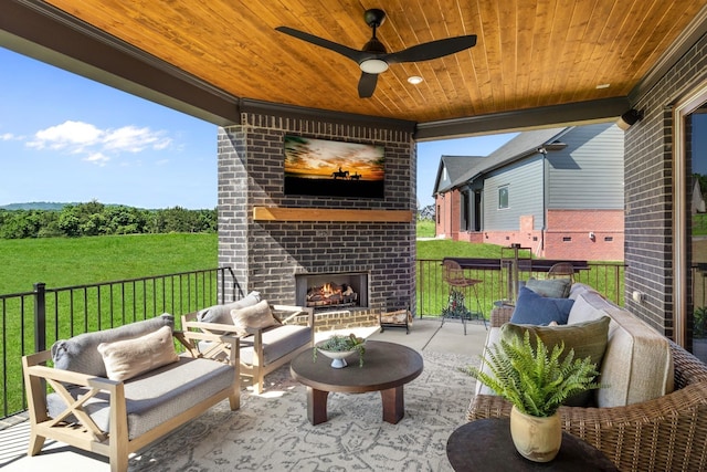 view of patio with an outdoor living space with a fireplace and ceiling fan