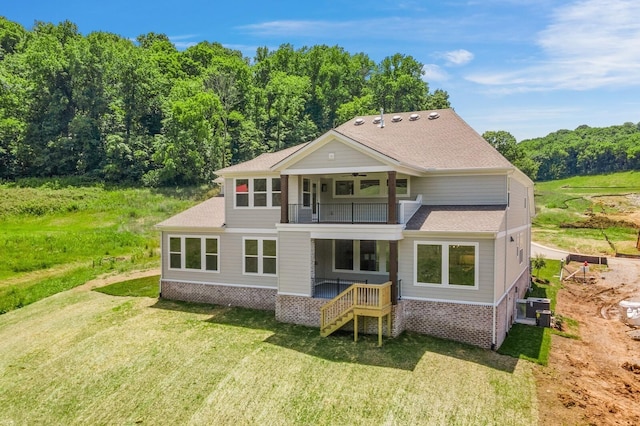 back of property with a lawn and a balcony