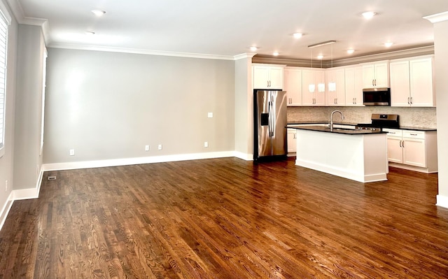 kitchen with stainless steel appliances, dark wood-type flooring, sink, a center island with sink, and white cabinets