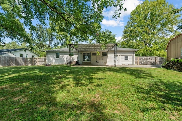 back of property with a lawn and a patio