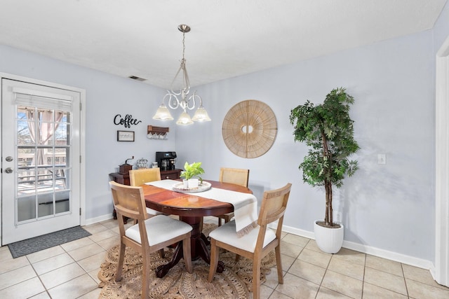 dining area with light tile patterned floors, a chandelier, visible vents, and baseboards