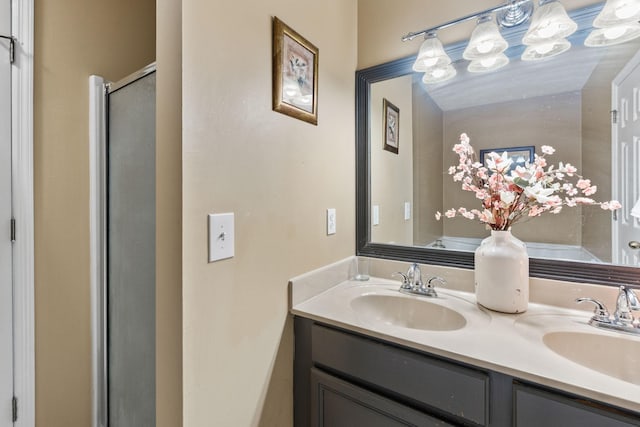 bathroom featuring a stall shower, a sink, and double vanity