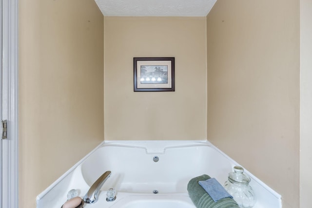 bathroom with a textured ceiling and a garden tub