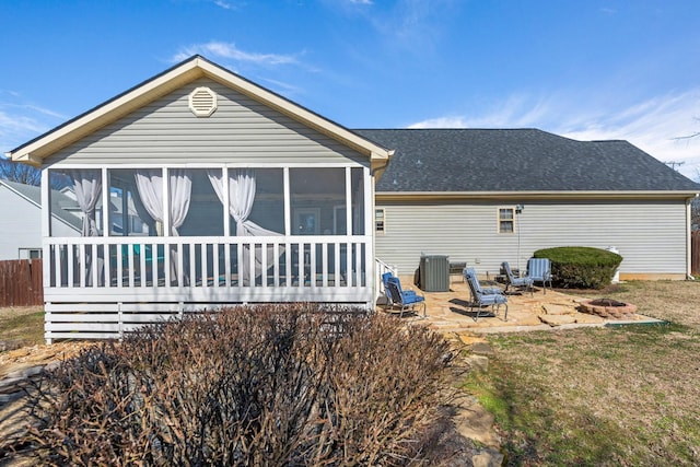 back of property with a sunroom, a patio area, central AC, and roof with shingles