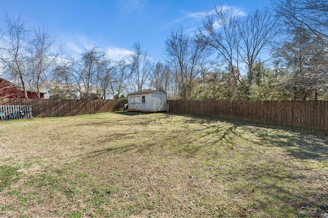 view of yard with a fenced backyard, an outdoor structure, and a storage unit