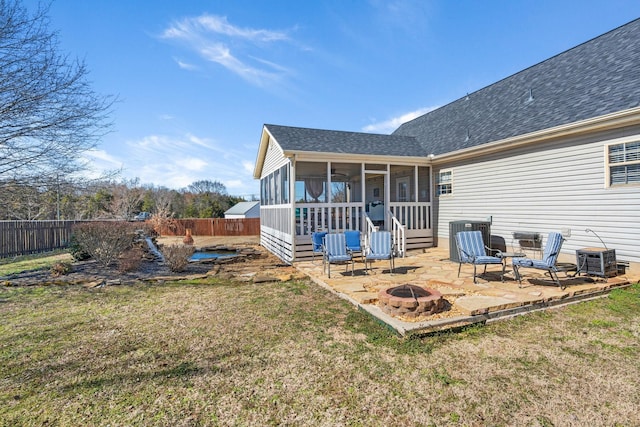 back of property featuring a sunroom, a fenced backyard, a patio, and a fire pit