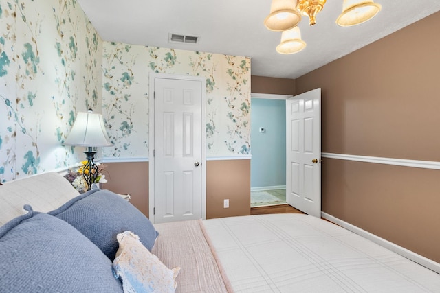 bedroom with visible vents, baseboards, and wallpapered walls