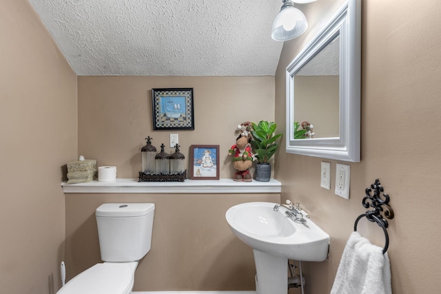 bathroom with a textured ceiling and toilet