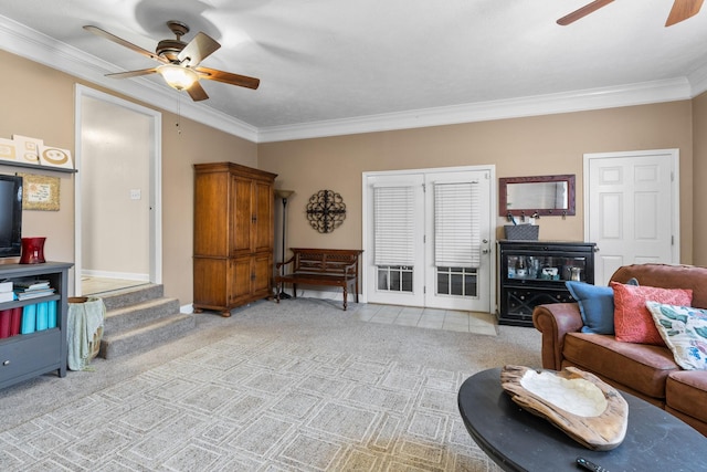 living room with ornamental molding, a ceiling fan, and light colored carpet