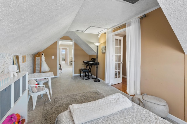 bedroom featuring visible vents, vaulted ceiling, a textured ceiling, and baseboards