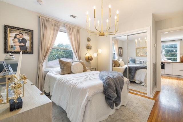 bedroom with hardwood / wood-style flooring, a closet, and a notable chandelier