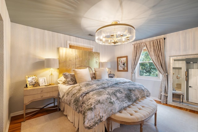 bedroom with light hardwood / wood-style floors and an inviting chandelier