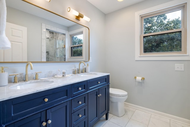 bathroom with a shower, vanity, a healthy amount of sunlight, and toilet