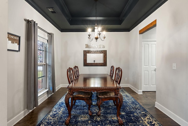 dining area featuring a tray ceiling, dark hardwood / wood-style flooring, ornamental molding, and an inviting chandelier