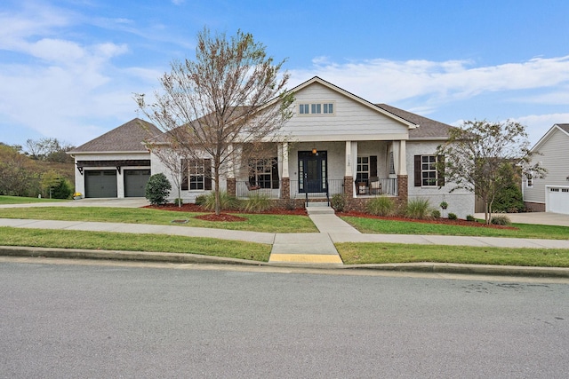 view of front of house featuring a front lawn, a porch, and a garage